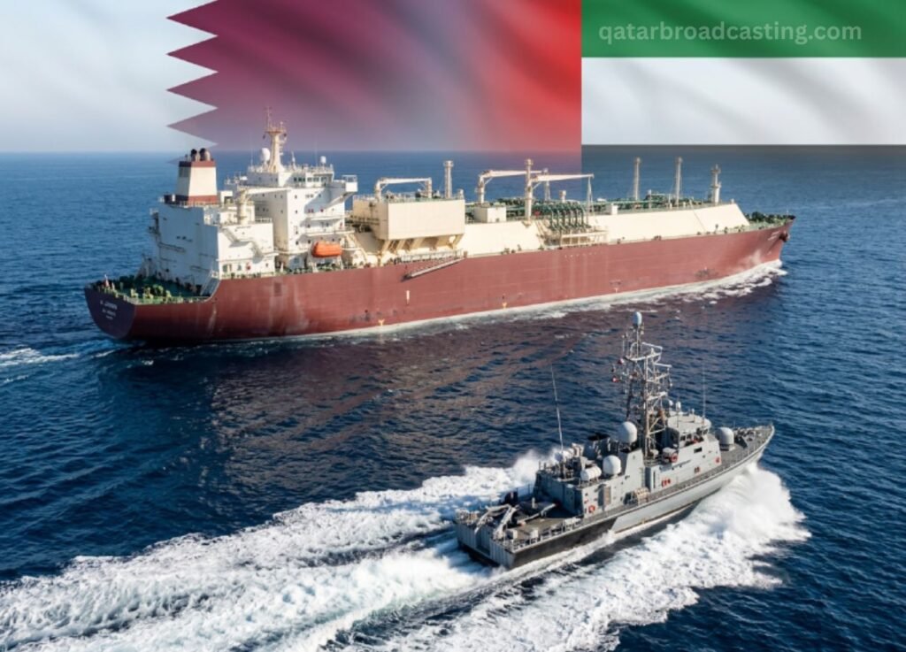 - Qatar Broadcasting A large red-hulled tanker sails in the open sea, escorted by a gray military ship speeding alongside; a Qatar flag banner sits across the top-right.